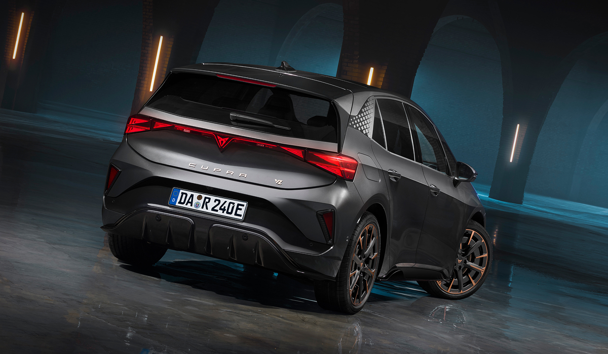 CUPRA Born in Blau auf einem Parkdeck vor beleuchteten Hochhäusern